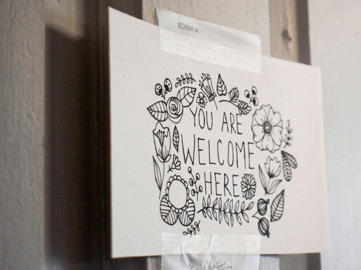 Hand drawn card hanging in therapist’s office reads “You are welcome here”.