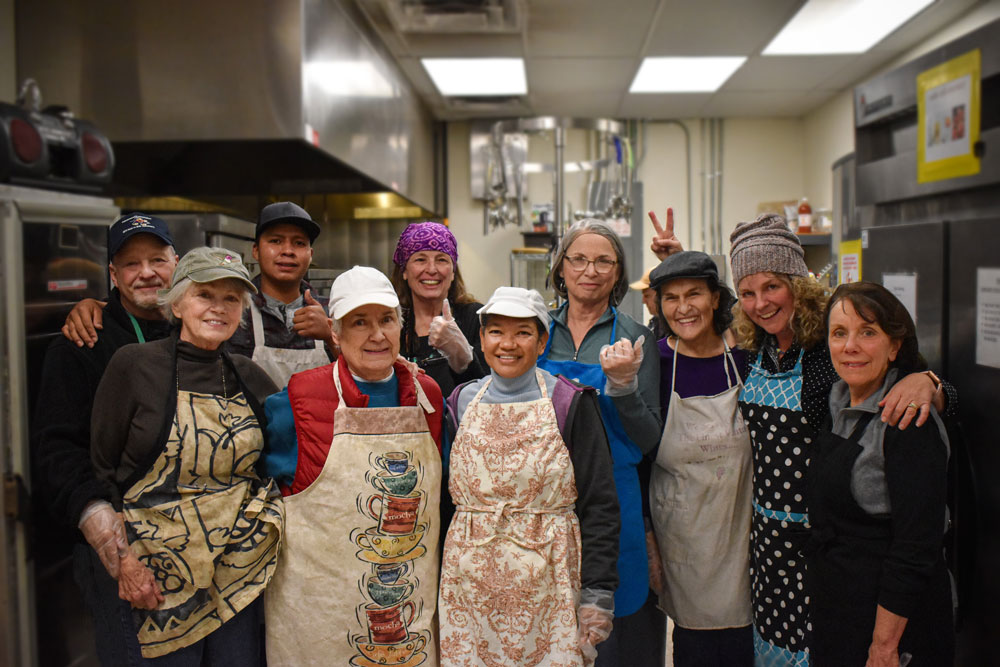 Volunteers from Unity Spiritual – Group of volunteers standing and smiling in the HopeWorks Day Shelter kitchen.