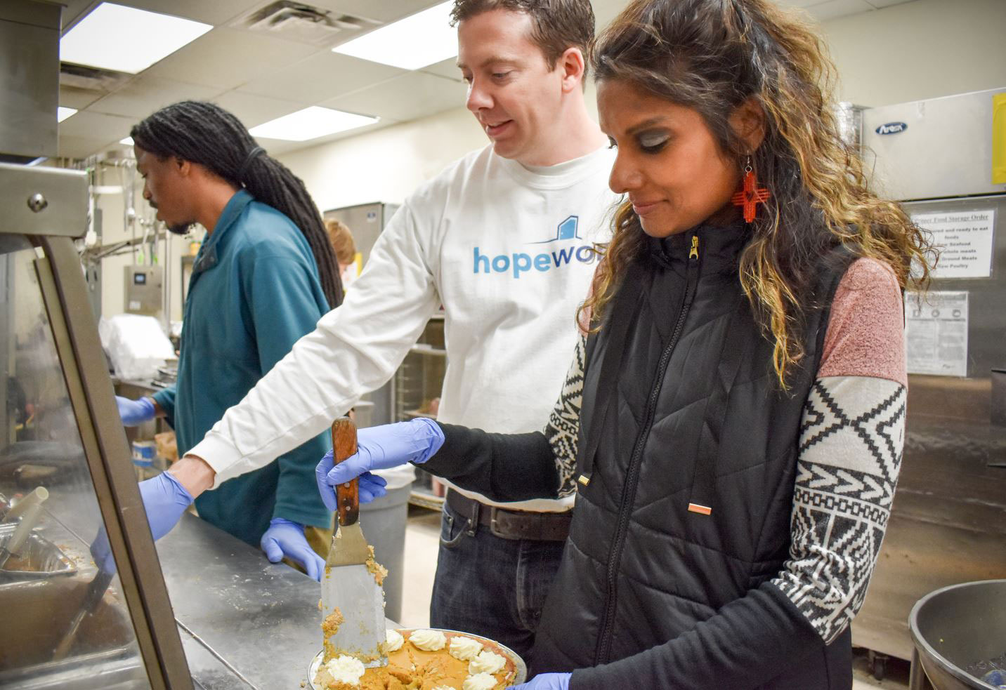 HopeWorks CEO, Annam Manthiram serving a meal to clients.